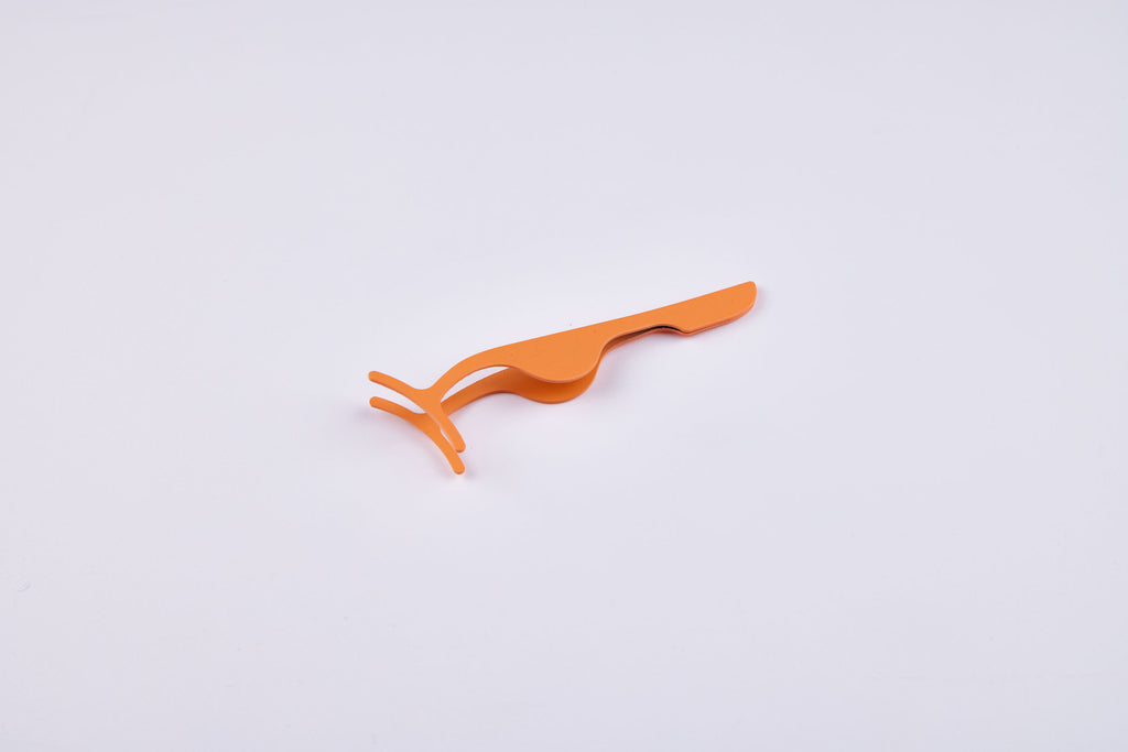Oranje lash applicator speciaal ontworpen voor het nauwkeurig aanbrengen van magnetische wimpers zonder schade.