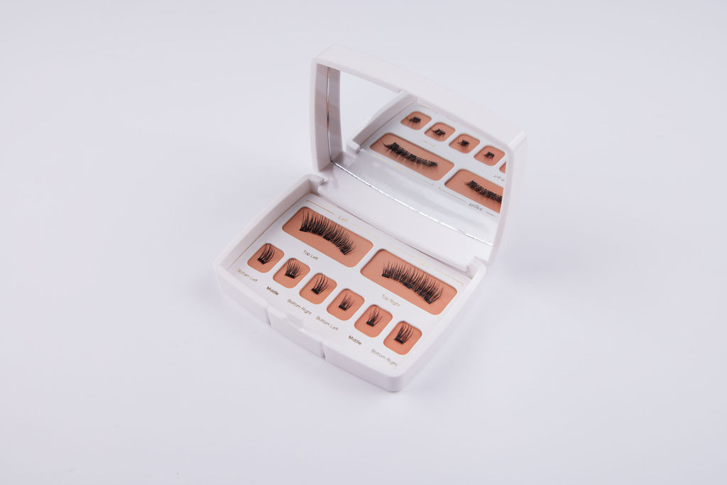 Luxie magnetische wimperkit geopend om de verschillende stijlen van herbruikbare wimpers te tonen met het merklogo 'LASHANDLUX' op de bovenkant van de witte doos.